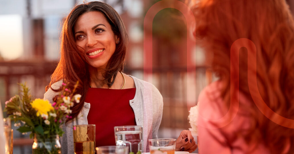 mulher sorrindo em uma mesa posta em um ambiente aberto